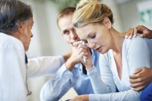 A woman reviewing divorce documents with his husband and a Las Vegas divorce lawyer.