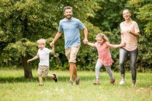 Parents happily running in the park with their kids in Las Vegas.